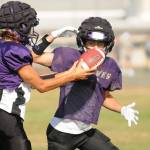 Sequim senior quarterback Kobe Applegate, left, prepares to hand off the football to Aiden Gockerell during a recent practice. The Wolves visit Forks tonight at 7 p.m. in the season opener for each school. (Michael Dashiell/Olympic Peninsula News Group)