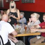 Bartender and server Lindsey Montgomery works to cash out a group of vaccinated customers at the Old Whiskey Mill in Port Townsend during the lunch rush Tuesday afternoon. (Zach Jablonski/Peninsula Daily News)