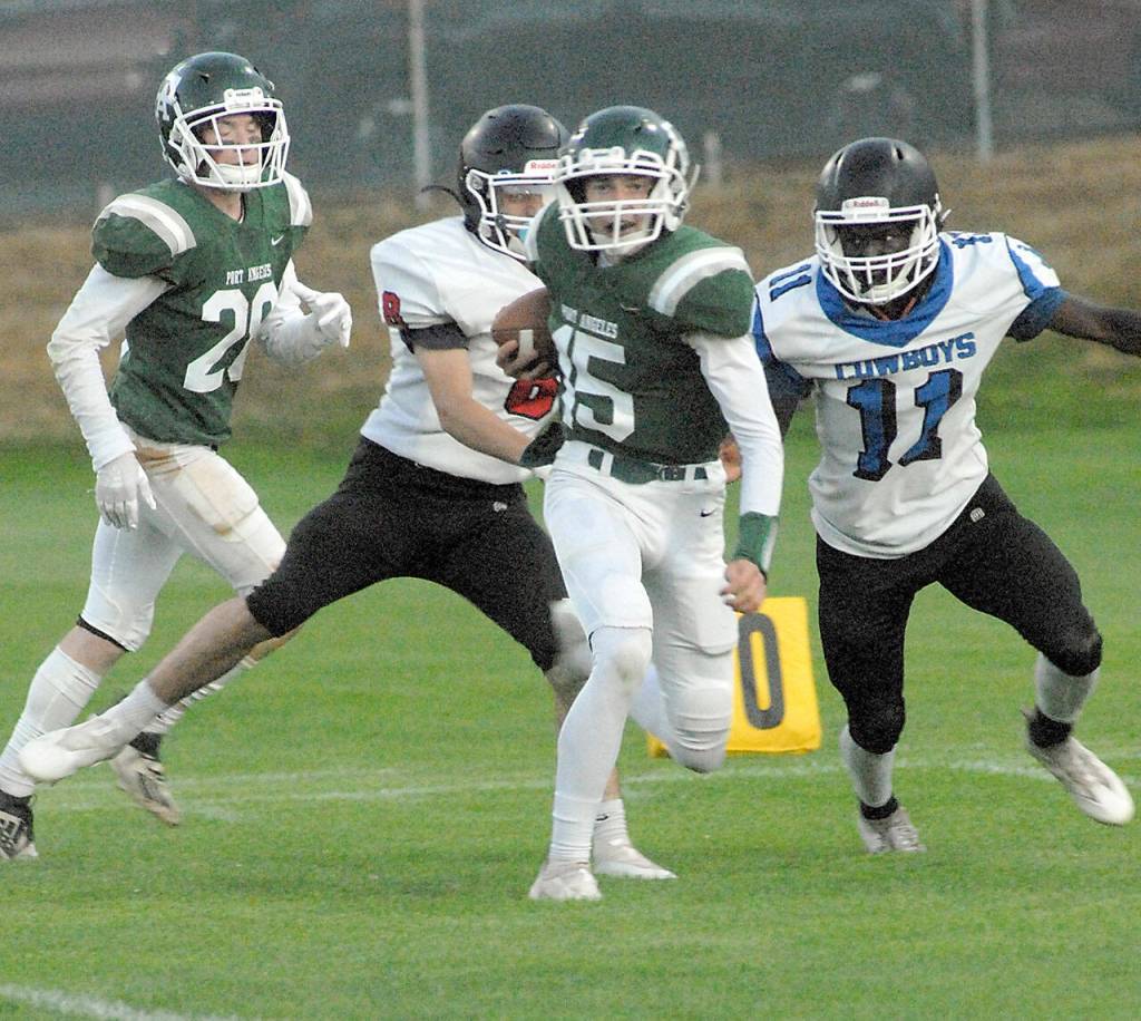 Keith Thorpe/Peninsula Daily News Port Angeles Parker Nickerson, center, slips past East Jeffersons Lonnie Kenney and Jerome Reaux Jr., right, as Nickersons teammate, Brantyn Fisler, left, follows behind on Friday at Port Angeles Civic Field.