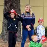 Liana Janssen, 10, left, along with Cameron Janssen, 8, and Holden Janssen, 6, came with their mom Vanessa to the East Jefferson Fire & Rescue station in Uptown Port Townsend on Saturday morning. Together with fire and police officials and civilians from around Jefferson County, they marked the 20th anniversary of 9/11. Before pausing for a minute of silence, EJFR crew members gave the youngsters shiny red fire helmets. (Diane Urbani de la Paz/Peninsula Daily News)