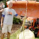 Duane Grego, left, and Dan Welden check the scales on Weldens winning pumpkin at 166.2 pounds Sunday. A giant pumpkin contest is conducted each year at the Evergreen Country Estates neighborhood on Goss Road south of Port Angeles. Welden, who started the contest 14 years ago, gives each of his neighbors special pumpkin sprouts he has started from seeds from the Northwest Giant Pumpkin Growers Association. The growing season starts around May 1 and the neighbors gather for a weigh-in and to have a pumpkin potluck party this time of year. Only one pumpkin weighed more than 100 pounds out of the dozen entries. (Dave Logan/For Peninsula Daily News)