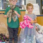 Nick, 5, and Josie, 4, of Great Futures Preschool, housed at the Sequim unit of the Boys & Girls Clubs of the Olympic Peninsula, hold stuffed animals sewn by members of the Sequim Fiber Arts Neighborhood Group of the American Sewing Guild for distribution at the club. (Emily Matthiessen/Olympic Peninsula News Group)