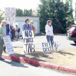 About 10 anti-vaccination protestors gather outside the Port Townsend High School campus Wednesday afternoon, holding a variety of signs such as "the vaccine is slow euthanasia" and equating getting the COVID-19 vaccine to playing a game of Russian roulette. (Zach Jablonski/Peninsula Daily News)