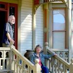 Oyster Races organizer Brian Cullin, left, and Quilcene Museum supporter Cleone Telling take in the sun on the porch of the 1892 Worthington Mansion in Quilcene. Sunday tours of the mansion are part of this weekends Quilcene Fair activities. (Diane Urbani de la Paz/Peninsula Daily News)