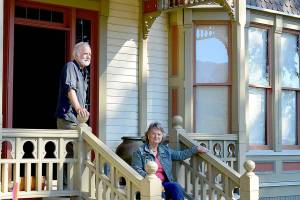 Oyster Races organizer Brian Cullin, left, and Quilcene Museum supporter Cleone Telling take in the sun on the porch of the 1892 Worthington Mansion in Quilcene. Sunday tours of the mansion are part of this weekends Quilcene Fair activities. (Diane Urbani de la Paz/Peninsula Daily News)