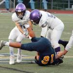 Toppy Robideau and Faas Christianson team up to make the tackle on Bainbridge quarterback Jack Grant. (Mark Krulish/Kitsap News Group)