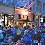 A flock of moviegoers came to see Lily Topples the World, Friday nights Port Townsend Film Festival outdoor cinema offering. With the Rose Theatre behind them, the crowd watched the documentary on a giant screen erected over Taylor Street in downtown Port Townsend. (Diane Urbani de la Paz/Peninsula Daily News)