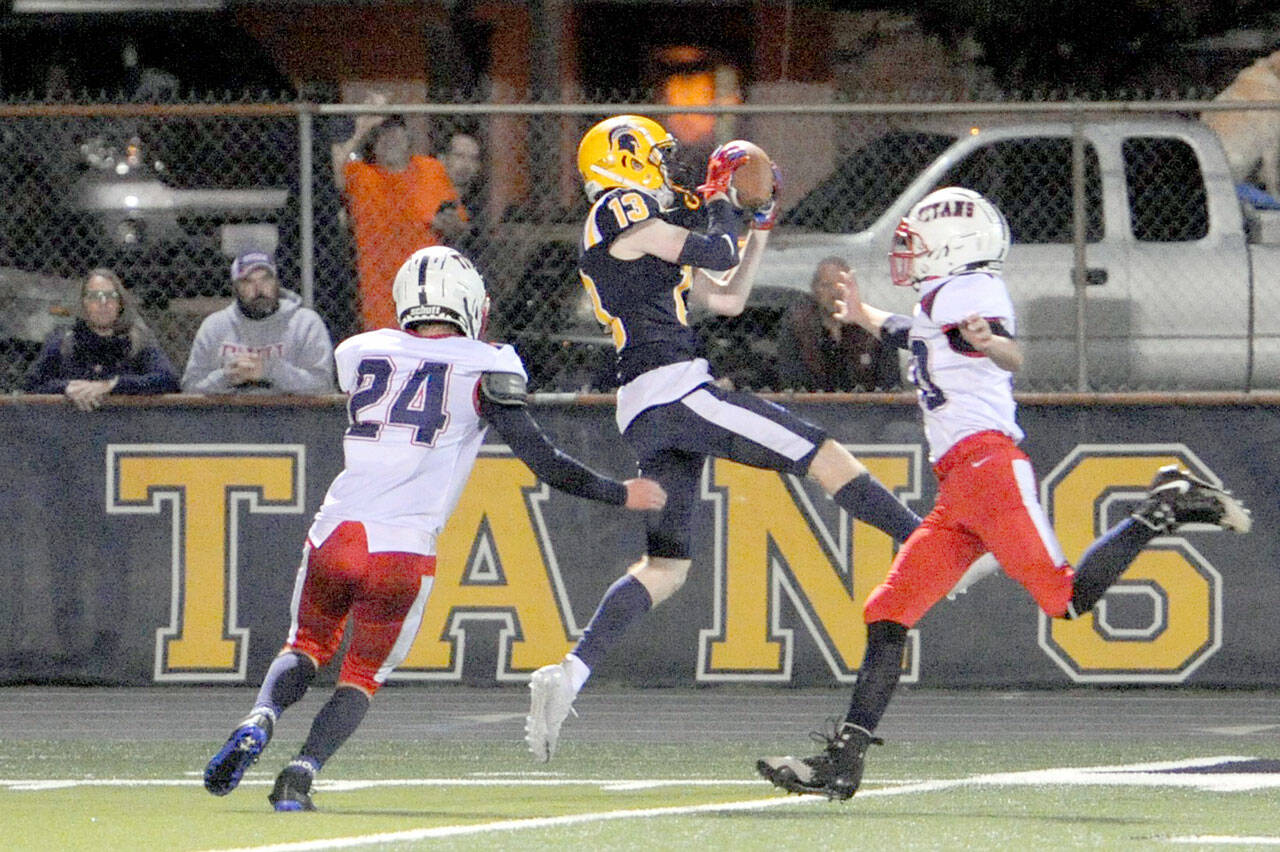 Spartan Ryan Rancourt (13) clutches a Logan Olson pass between two Titan defenders Friday night at Spartan Stadium where Forks defeated Pe Ell-Willapa Valley 22 to 21 in a thriller. Photo by Lonnie Archibald.
Spartan Ryan Rancourt (13) clutches a Logan Olson pass between two Titan defenders Friday night at Spartan Stadium where Forks defeated Pe Ell-Willapa Valley 22 to 21 in a thriller. (Lonnie Archibald/for Peninsula Daily News)