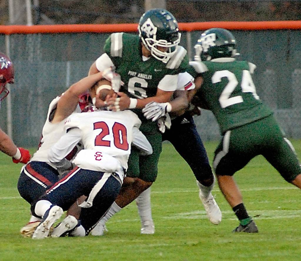 Keith Thorpe/Peninsula Daily News Port Angeles Jaziel Livingston, center, is wrapped up by the Kennedy Catholic defense, including Isiah Malloe, front, as teammate Jeremiah Hall, right, tries to assist on Friday night in Port Angeles.