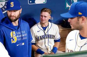 Seattle Mariners Jarred Kelenic, center, sits in the dugout after his team lost to the Los Angeles Angels in a baseball game Sunday in Seattle. (Elaine Thompson/The Associated Press)