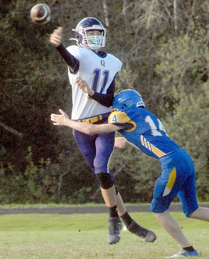 Keith Thorpe/Peninsula Daily NEws Quilcene quaterback Nathan Kieffer passes before being tackled by Crescents Cole Grooms on Thursday at Crescent High School.