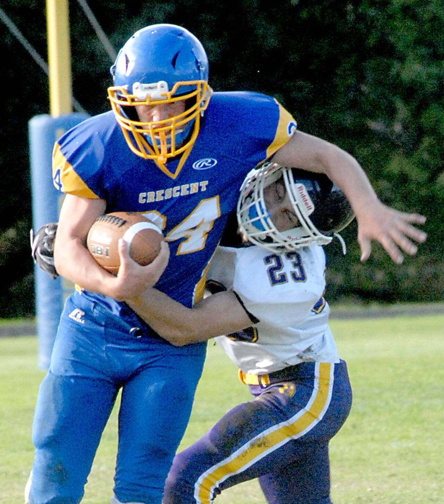 Keith Thorpe/Peninsula Daily News Crescents Brayden Emery tries to evade Quilcenes Thacker Cash on Thursday in Joyce.