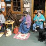 From left, Jennifer Pelikan, Sue Shane, Jessica Mishler, and Linda Offutt are shown Saturday morning at the Forks Timber Museum demonstrating Spinning, knitting and sewing.  Photo by Lonnie Archibald.