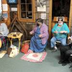 From left, Jennifer Pelikan, Sue Shane, Jessica Mishler, and Linda Offutt are shown Saturday morning at the Forks Timber Museum demonstrating spinning, knitting and sewing. (Lonnie Archibald/For Peninsula Daily News)