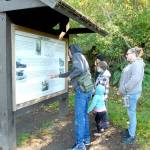 Members of the Pease family of Sequim, from left, father, Craig, children Addison, 12, Alayna, 10 and Alivia, 3, and mother, Bambi, examine an information kiosk at Salt Creek Recreation Area north of Joyce last week. The group was exploring places on the North Olympic Peninsula. (Keith Thorpe/Peninsula Daily News)