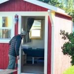 Kellen Lynch of the Housing Solutions Network peers inside one of the Pats Place tiny homes in Port Townsend on Friday. (Diane Urbani de la Paz/Peninsula Daily News)