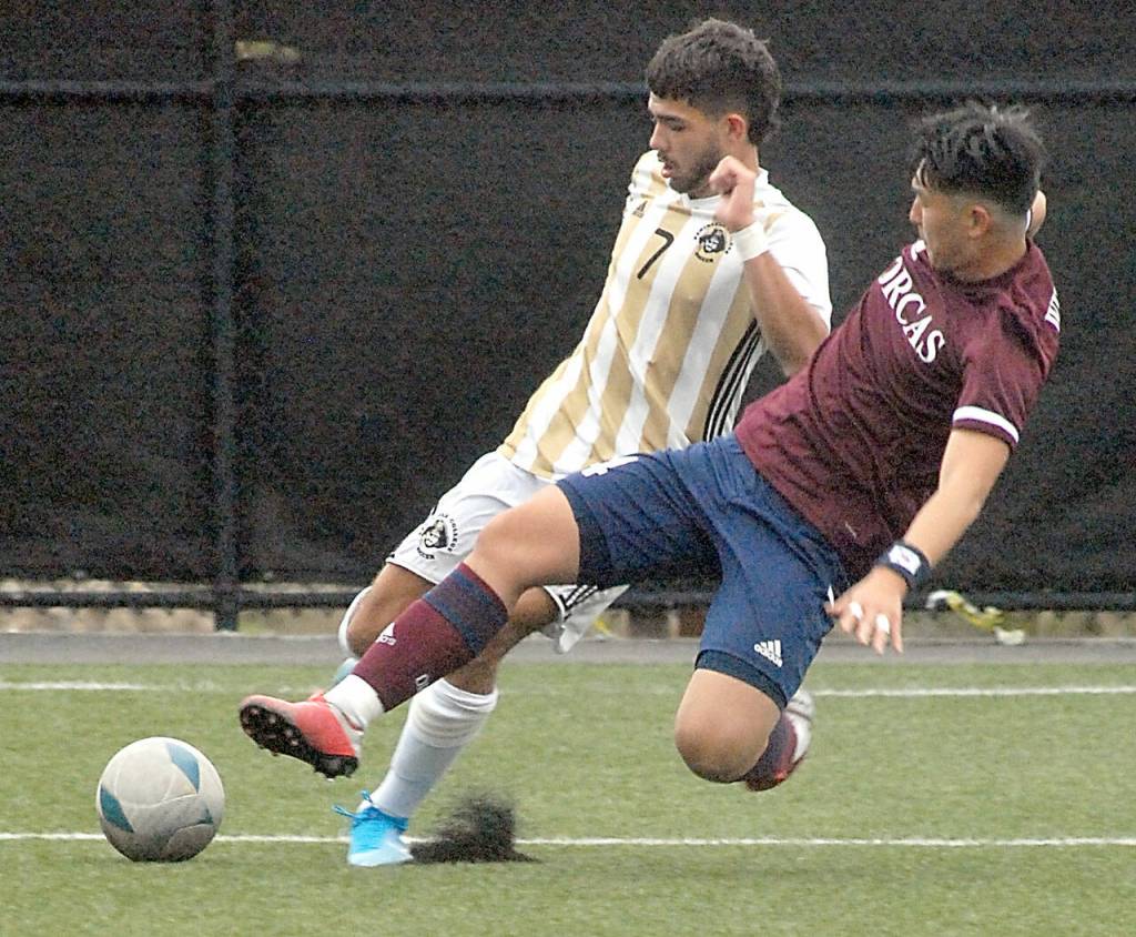 Peninsulas Jonathan DeMotta, left, tries to avoid a tackle from Whatcoms Inseong Park on Saturday at the Wally Sigmar Sports Complex. (Keith Thorpe/Peninsula Daily News)
Peninsulas Jonathan DeMotta, left, tries to avoid a tackle from Whatcoms Inseong Park on Saturday at the Wally Sigmar Sports Complex. (Keith Thorpe/Peninsula Daily News)