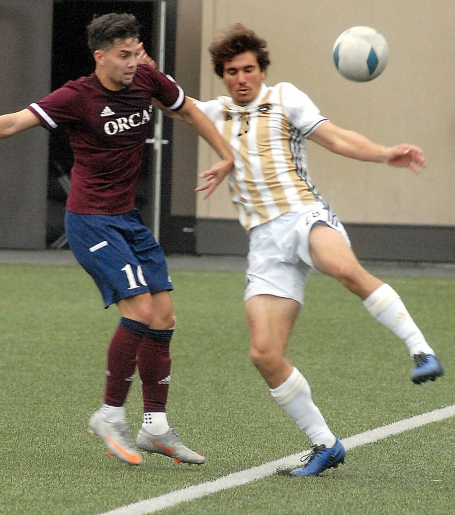 Peninsulas Kai Biegler, right, struggles to keep the ball inbounds as Whatcoms Nate Balauro looks on during Saturdays match in Port Angeles. (Keith Thorpe/Peninsula Daily News)