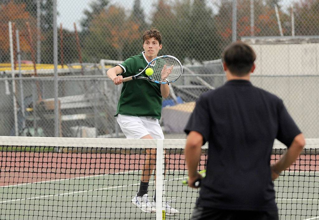 Port Angeles No. 2 doubles player James Burkhardt returns a shot against Sequims Espn Judd and Kaiden Jones during the Wolves 4-3 match victory on Thursday. (Michael Dashiell/Olympic Peninsula News Group)