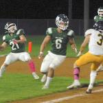 Keith Thorpe/Peninsula Daily News Port Angeles Daniel Cable, left, slips back to pass after receiving a lateral pass from quarterback Parker Nickerson, far right, as teammate Jaziel Livingston sets up to block Bainbridges Jeff Utter on Friday in Port Angeles.
