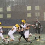 Forks running back Nate Dahlgren (40) picks up yardage during a deluge behind the blocking of Conner Earls (56) and Kalab Blanton (11). (Lonnie Archibald /for Peninsula Daily News)