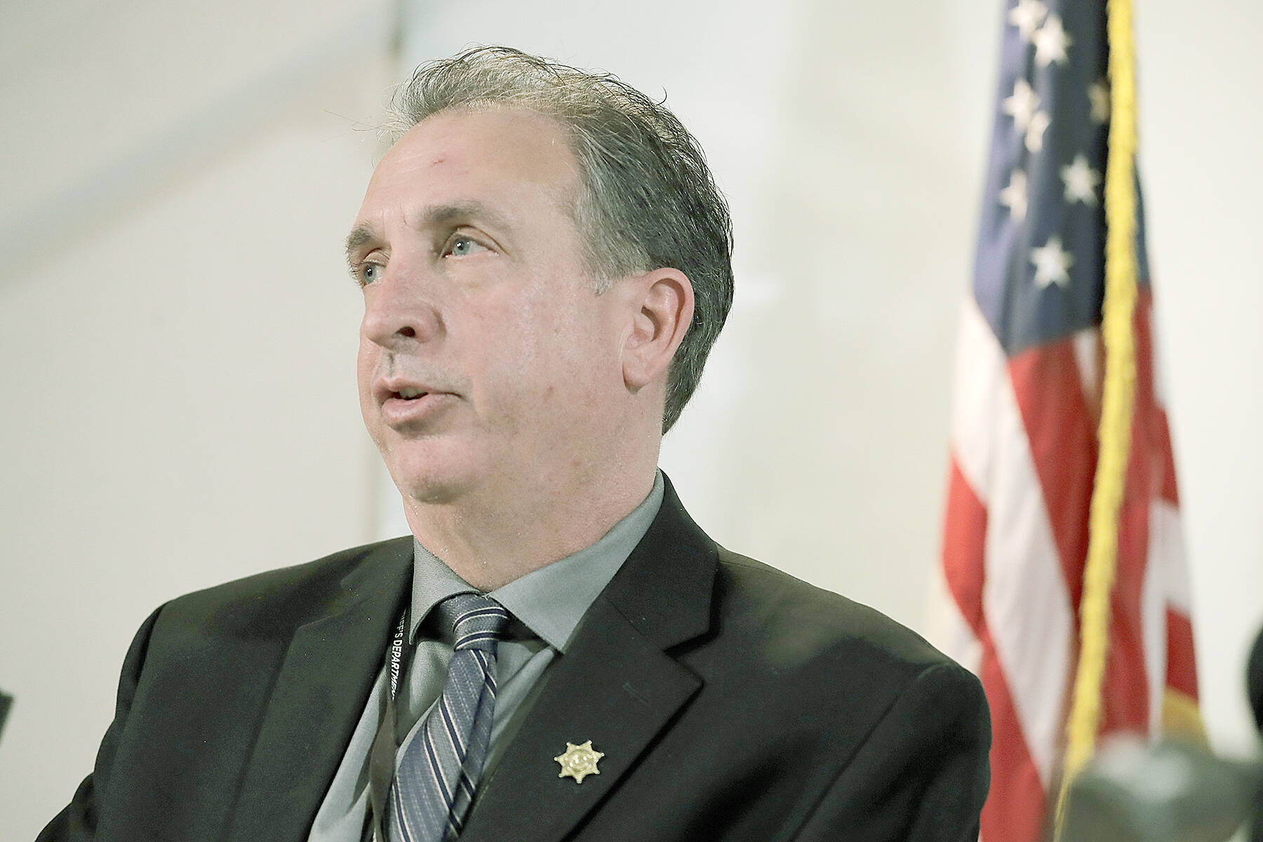 FILE - In this Feb. 18, 2020, file photo, then-Pierce County Sheriff's Dept. spokesman Det. Ed Troyer answers questions during a news conference in Tacoma, Wash. The Washington state attorney general on Tuesday, Oct. 19, 2021, filed two misdemeanor criminal charges against Troyer, now the Pierce County sheriff, stemming from his confrontation with a Black newspaper carrier in January. Troyer has denied wrongdoing. (AP Photo/Ted S. Warren, File)