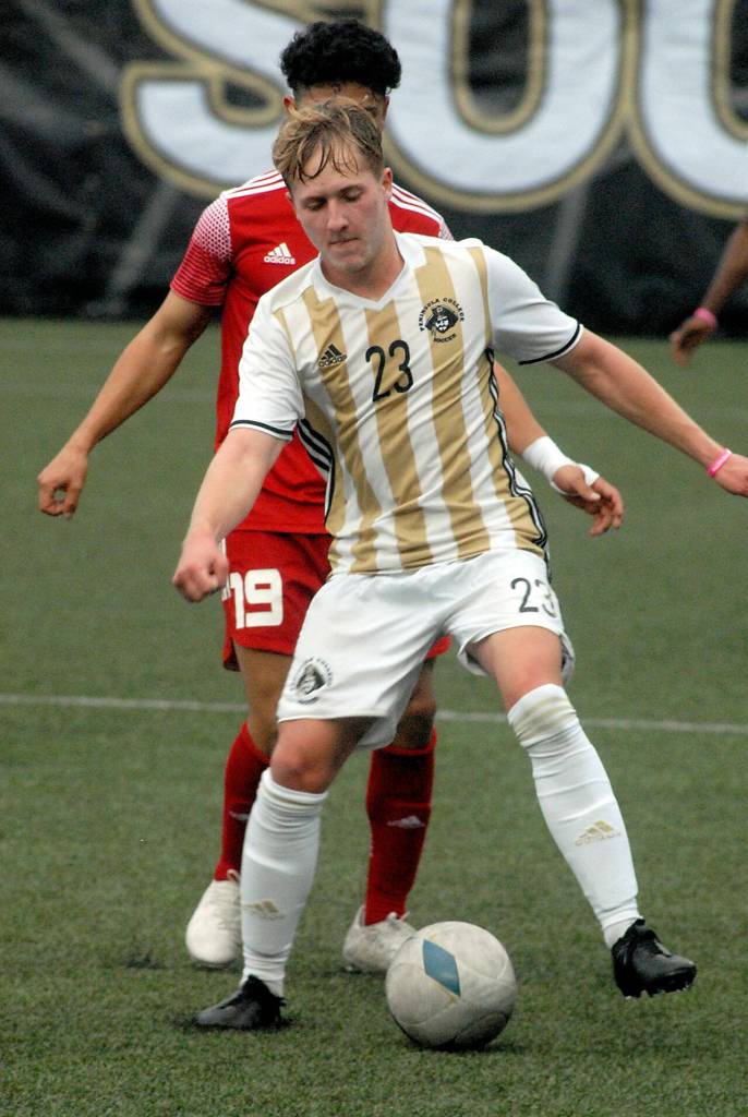 Peninsulas Tim Deser, front, dribbles in front of Skagit Valleys Sergio Garduno Mendez on Wednesday at Wally Sigmar Field in Port Angeles. (Keith Thorpe/Peninsula Daily News)