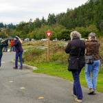 A group of friends on a walk at Fort Worden State Park on Thursday hold their ears to muffle the loud siren noise from the tsunami warning device going off during the Great ShakeOut drill. Friends, family and co-workers were supposed to practice movements to drop, cover and hold on to build muscle memory to be prepared for an earthquake. (Steve Mullensky/for Peninsula Daily News)