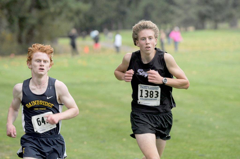 Group Sequim sophomore Colby Ellefson, right, runs alongside Bainbridges Alexander Miller during the Olympic League Cross Country Championships at The Cedars at Dungeness. Ellefson finished third in the boys race. (Michael Dashiell/Olympic Peninsula News)