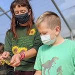 Educator Carrie Walker works with students in Quilcene at the school garden, one of the locations supported by the Jefferson County Community Wellness Project. The project, which has its dinner-and-a-movie event Thursday, connects local schools, gardens and farms.  photo courtesy Community Wellness Project