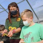 Educator Carrie Walker works with students in Quilcene at the school garden, one of the locations supported by the Jefferson County Community Wellness Project. The project, which has its dinner-and-a-movie event Thursday, connects local schools, gardens and farms. photo courtesy Community Wellness Project