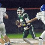 Keith Thorpe/Peninsula Daily News
Port Angeles quarterback Parker Nickerson, center, looks downfield as Olympic's Jacob Gesell, left, and Alexander Larson, right, close in on Friday night at Port Angeles Civic Field.