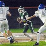 Port Angeles quarterback Parker Nickerson, center, looks downfield as Olympics Jacob Gesell, left, and Alexander Larson, right, close in on Friday night at Port Angeles Civic Field. (Keith Thorpe/Peninsula Daily News)
