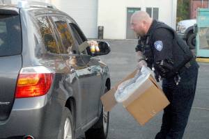 Keith Thorpe/Peninsula Daily News
Officer Mike Johnson of the Port Angeles Police Department accepts a drop-off of unwanted drugs on Saturday in the parking lot of the Clallam County Courthouse as part the National Prescription Drug Take Back Day. The annual event, organized by the U.S. Drdug Enforcement Administration, allowed people to get rid of potentially dangerous expired, unused and unwanted prescription drugs for safe disposal.