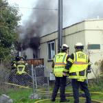 Keith Thorpe/Peninsula Daily News
Clallam County Fire District 2 firefighters work to extinguish a blaze in a single-wide house trailer at 2413 E. Pioneer Road in the Gales Addition east of Port Angeles on Tuesday.