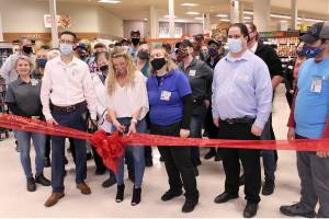 Rachel Hill, the e-commerce lead for the Port Townsend Safeway, cuts the ribbon during the store's "Grand Reopening" on Wednesday while surrounded by current and retired employees of the store. Hill has worked for the Port Townsend grocery store for 32 years. 
The reopening is celebrating the completion of a four-month remodel for the store that began after the Fourth of July. The remodel brought in new refrigeration units, display windows for the departments like the deli and meat/seafood, new paint and a new "Ready? Go" section of pre-cooked meals. (Zach Jablonski/Peninsula Daily News)