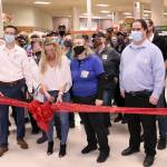 Rachel Hill, the e-commerce lead for the Port Townsend Safeway, cuts the ribbon during the stores Grand Reopening on Wednesday while surrounded by current and retired employees of the store. (Zach Jablonski/Peninsula Daily News)