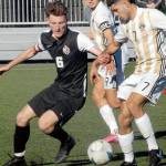 Peninsulas Jonathan DeMotta, right, tangles with Everetts Liam Raney on Saturday as Peninsulas Nicolas Hernandez keeps sight of the ball. (Keith Thorpe/Peninsula Daily News)