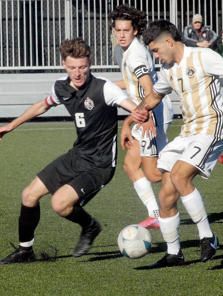 Peninsulas Jonathan DeMotta, right, tangles with Everetts Liam Raney on Saturday as Peninsulas Nicolas Hernandez keeps sight of the ball. (Keith Thorpe/Peninsula Daily News)