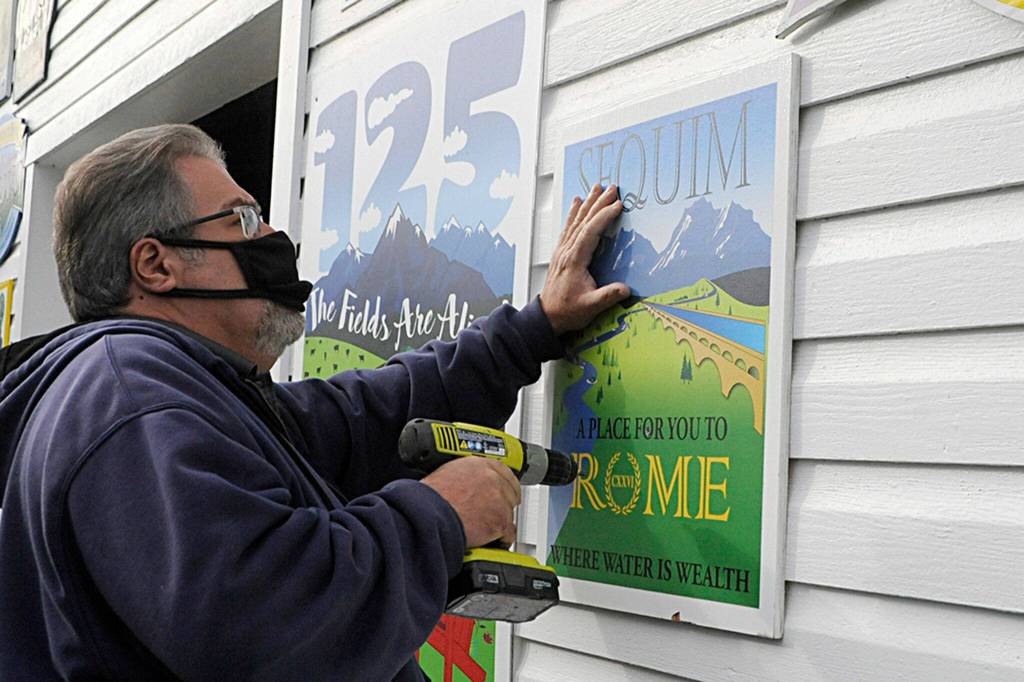 Outside the float barn, Guy Horton hangs up this years royalty floats sign. I thought this year was an amazing float, he said. It was his 14th and final float, he said as he plans to focus more on work and family- and self-care. (Matthew Nash/Olympic Peninsula News Group)