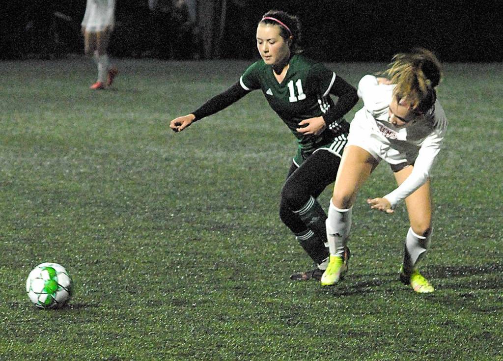 Port Angeles Savannah Croteau, left, and Enumclaws Grace McCain chase a loose ball on Tuesday night at Peninsula College in Port Angeles. (Keith Thorpe/Peninsula Daily News)
