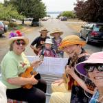 From left, Patricia Bolen, Geoff Fong, Anne Ficarra, Walter Vaux, Debbie Littlejohn and Terri Alexander ride on the Ukuleles Unite float, preparing for the August 2021 Rhody Parade in Port Townsend. The ukulelists are part of Bolens support system as she recovers from a difficult series of events. (Ukuleles Unite)
