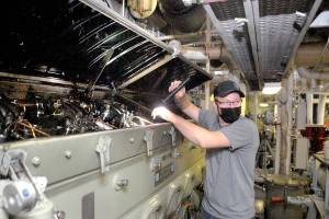 Keith Thorpe/Peninsula Daily News
Nick Anderson, ship's oiler for the MV Coho, performs a topside inspection of the starboard engine on Friday in preparation for the resumption of ferry service from Port Angeles to Victoria on Monday.