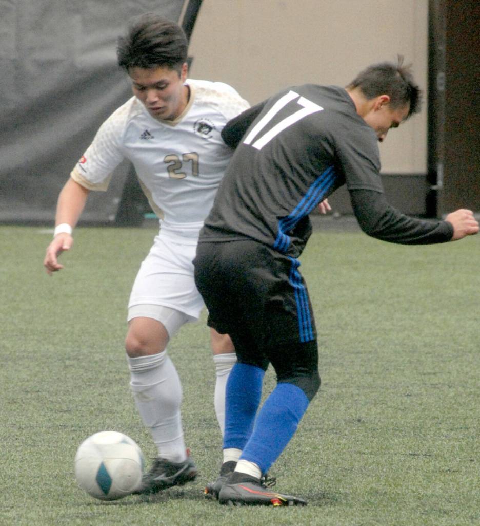 Keith Thorpe/Peninsula Daily News Peninsulas Yusaku Shimakura looks for a way around Rogues Randy Rodriguez on Saturday at Wally Sigmar Field in Port Angeles.