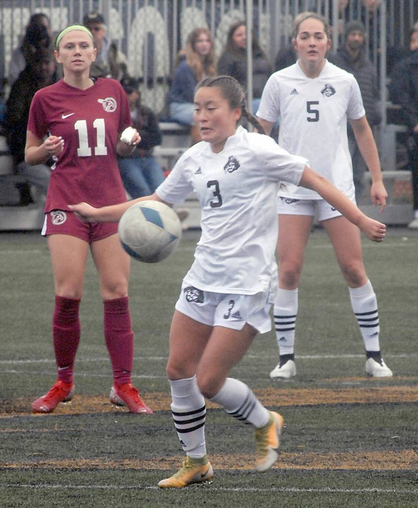 Peninsulas Shyanne Chang, front, stops an advancing ball as Pierces Madison Ryneski, left, and Peninsulas Kascia Muscutt look on during Saturdays match in Port Angeles. (Keith Thorpe/Peninsula Daily News)
