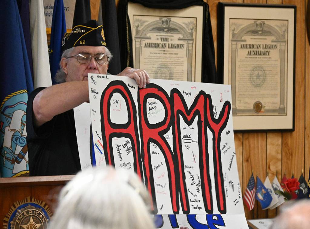 Carl Bradshaw, 1st vice Commander of the American Legion Jack Grennan Post No. 26 in Sequim, displays banners honoring the branches of the U.S. Armed Forces that were made by Sequim Middle School students. (Michael Dashiell/Olympic Peninsula News Group)