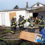 Firefighters for Clallam County Fire District 2 prepare for training on Saturday at a donated house at 2354 E. Fifth Ave. in the Gales Addition east of Port Angeles. The unoccupied house is scheduled to be used for live fire training after noon today when the structure will be ignited and burned to the ground for firefighters to hone their skills in a controlled fire situation. People seeing the blaze or corresponding smoke column are requested not to call 9-1-1. (Keith Thorpe/Peninsula Daily News)