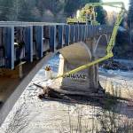 Washington State Department of Transportation bridge inspectors Jim Patton, left, and Mitch Stone examine the bridge supports of the U.S. Highway 101 bridge over the Elwha River on Tuesday after it was closed Monday amid concerns about possible storm damage to the footings. (Keith Thorpe/Peninsula Daily News)