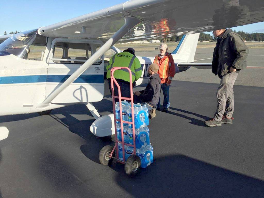 Volunteers with the Disaster Airlift Response Team (DART) work Tuesday afternoon to deliver about 180 cases of water to Sekiu, as residents are without water due to a water main break caused by Mondays rainstorms. (Alan Barnard)