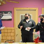 Bob Bindschadler of the Quilcene-Brinnon Garden Club, standing at left, and club president Ruth Dunham, seated, presented a $500 check to Brinnon Fire & Rescue chief Tim Manly, second from right, and Quilcene Fire & Rescue Lt. Nick Singleton last Thursday. Manly will use the funding to buy Guardian Angel LED safety lights for rural first responders to wear. Diane Urbani de la Paz/Peninsula Daily News